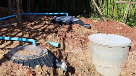 Black PE septic tank. Plastic septic tank and cement pipe are buried in the soil and PVC pipe is connected to treat waste in outdoor construction site with copy space. selective focus